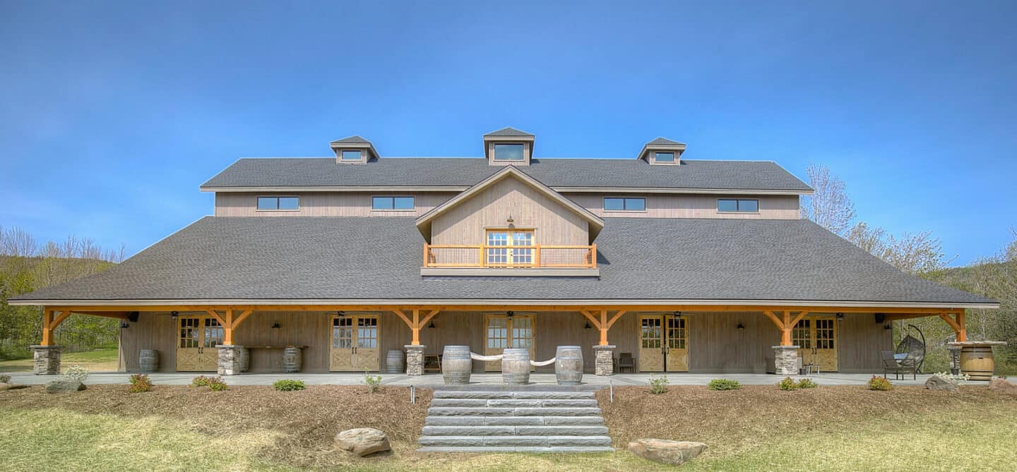 Elegant timber frame barn home set in a scenic mountain landscape, showcasing natural materials and.