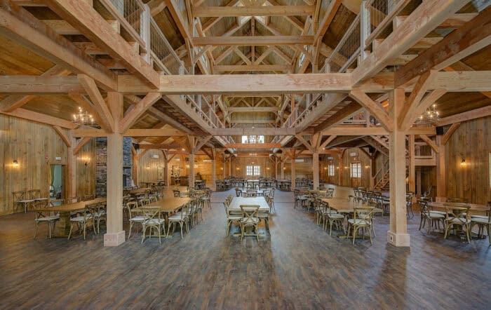 Custom timber frame barn home with natural materials in scenic mountain setting.