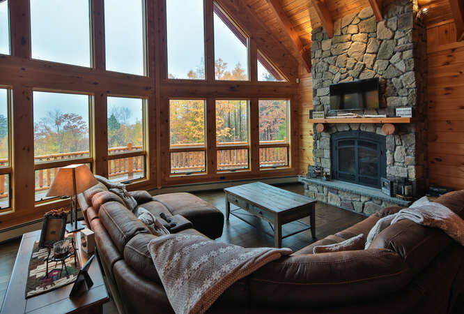 Custom log home with stone fireplace in a scenic mountain setting, natural materials, and rustic cra.