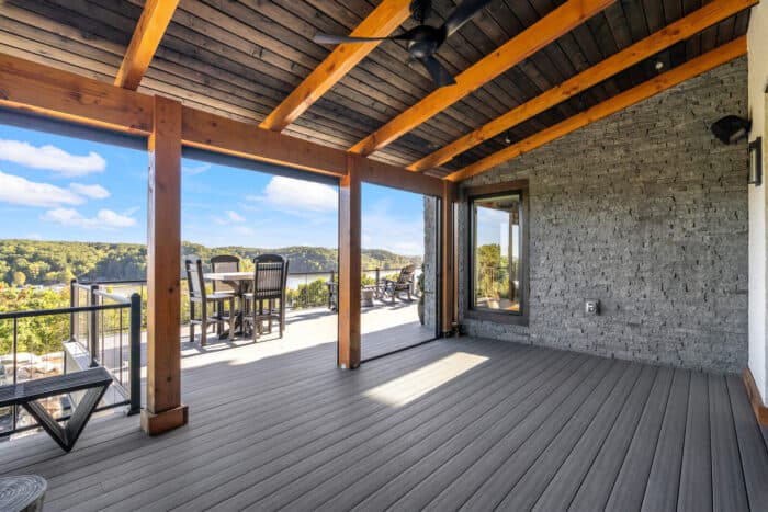 Elegant mountain lodge porch with natural wood beams and scenic lakeside views, showcasing custom lo.