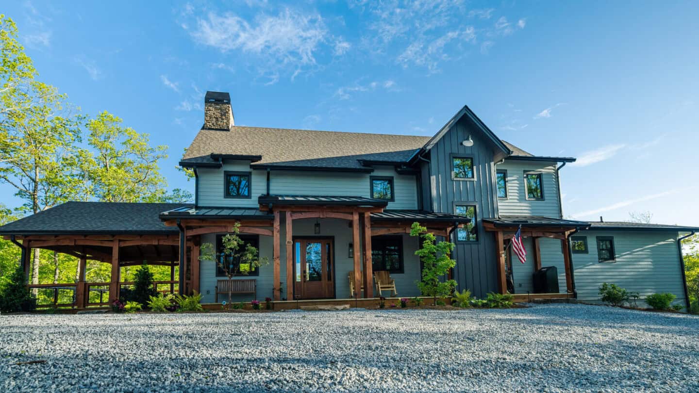 Elegant hybrid timber frame home with natural materials set against a scenic mountain backdrop, show.
