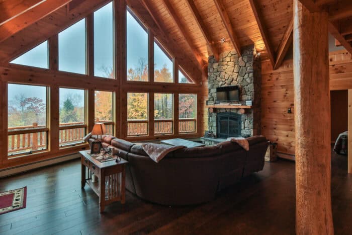 Custom log cabin with large windows, mountain setting, natural wood, and stone accents for a cozy, r.