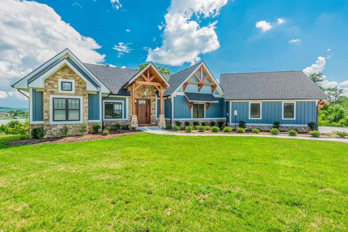 Custom mountain home with natural materials, timber frame and hybrid design in scenic lakeside setti.