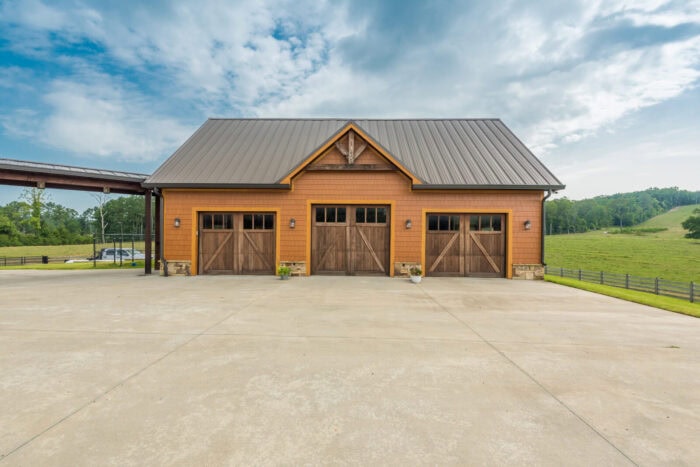 Elegant timber frame garage with natural wood accents set against scenic countryside, showcasing cus.