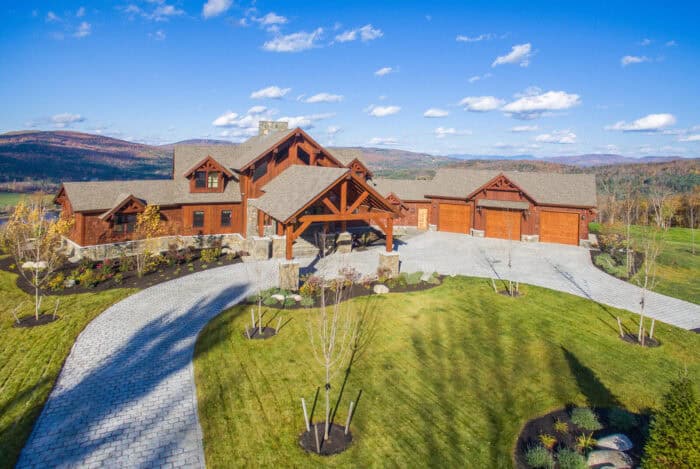 Elegant log cabin home with natural materials set in a scenic mountain landscape, showcasing custom.