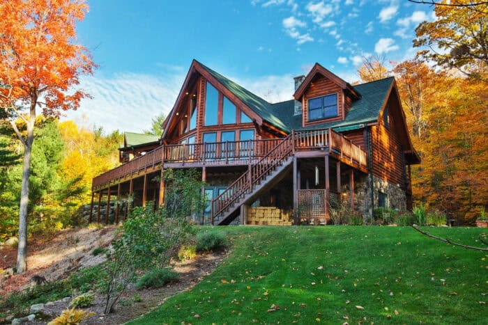 Custom log cabin home with timber frame architecture in a scenic mountain setting.