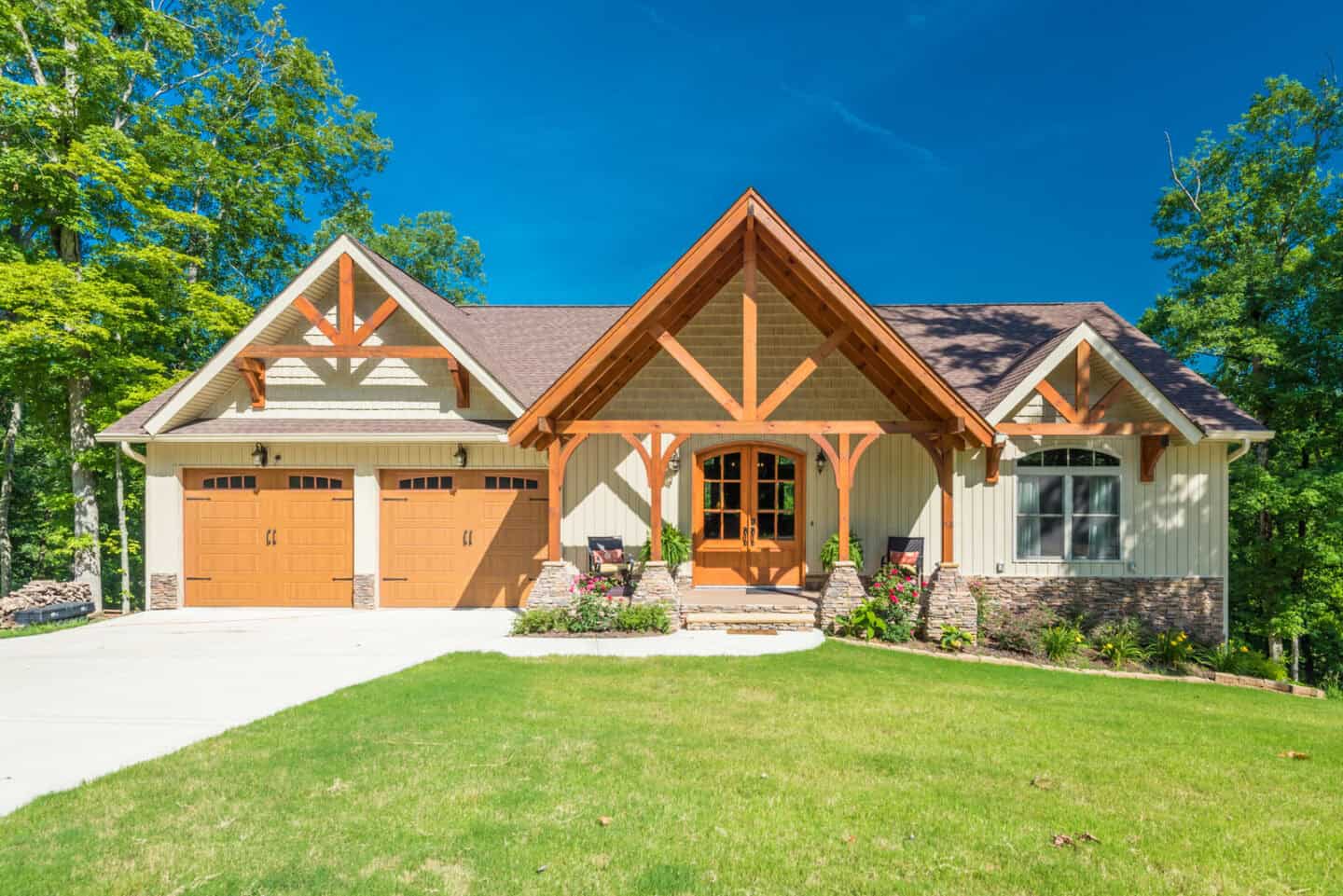 Custom natural home with timber frame and stone accents in a scenic mountain setting.